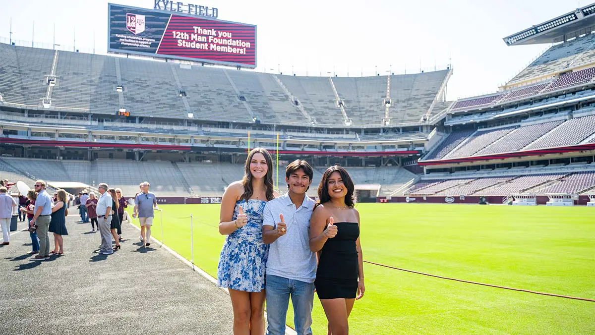 people giving thumbs up in stadium