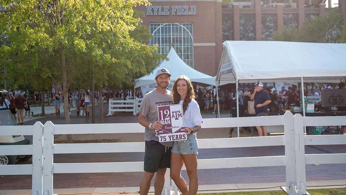 man and women holding 75 years sign