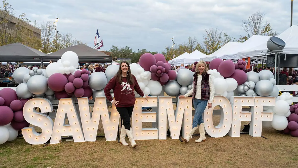 women posing in front of sign